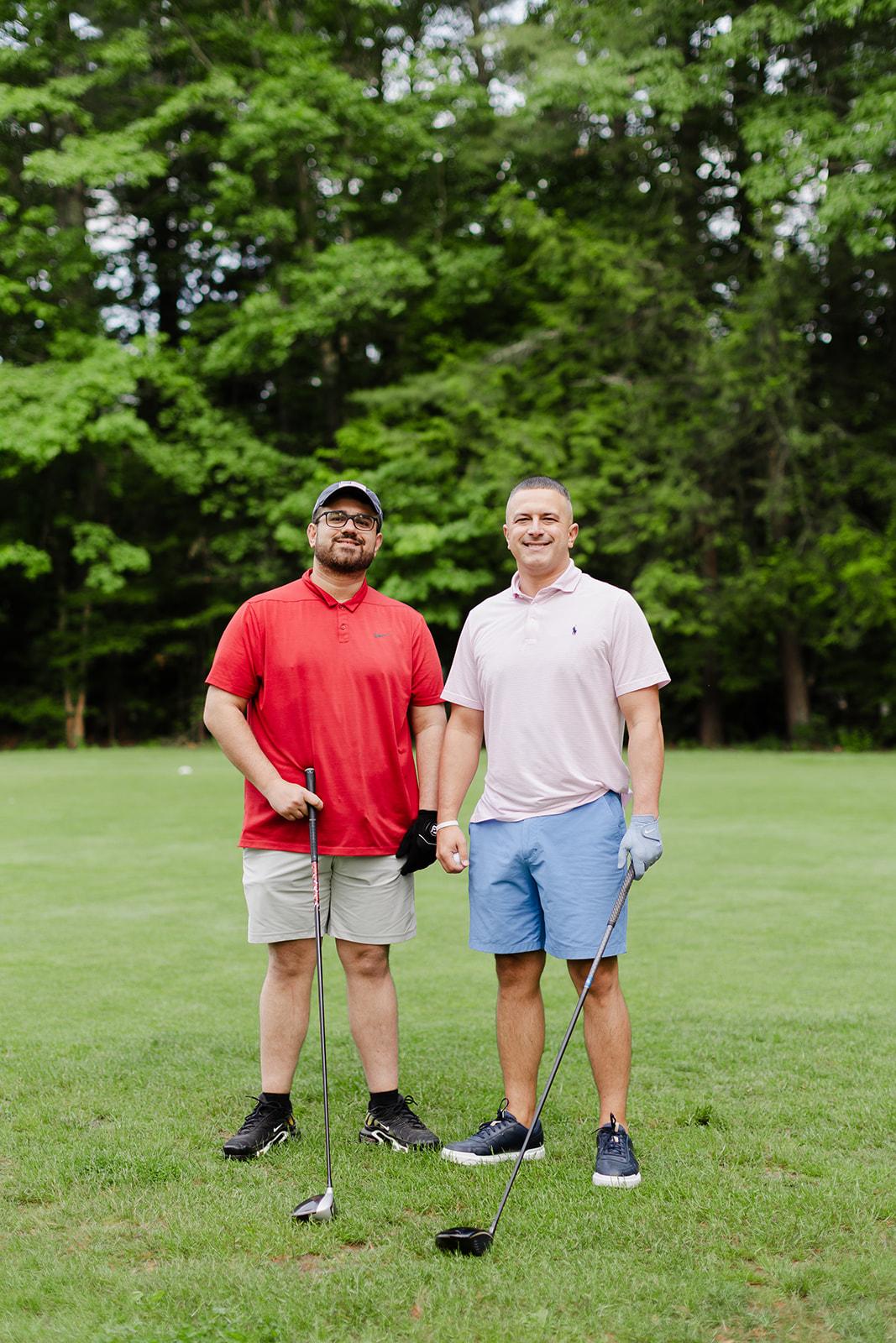 Two teammates sharing a laugh on the green during the golf outing