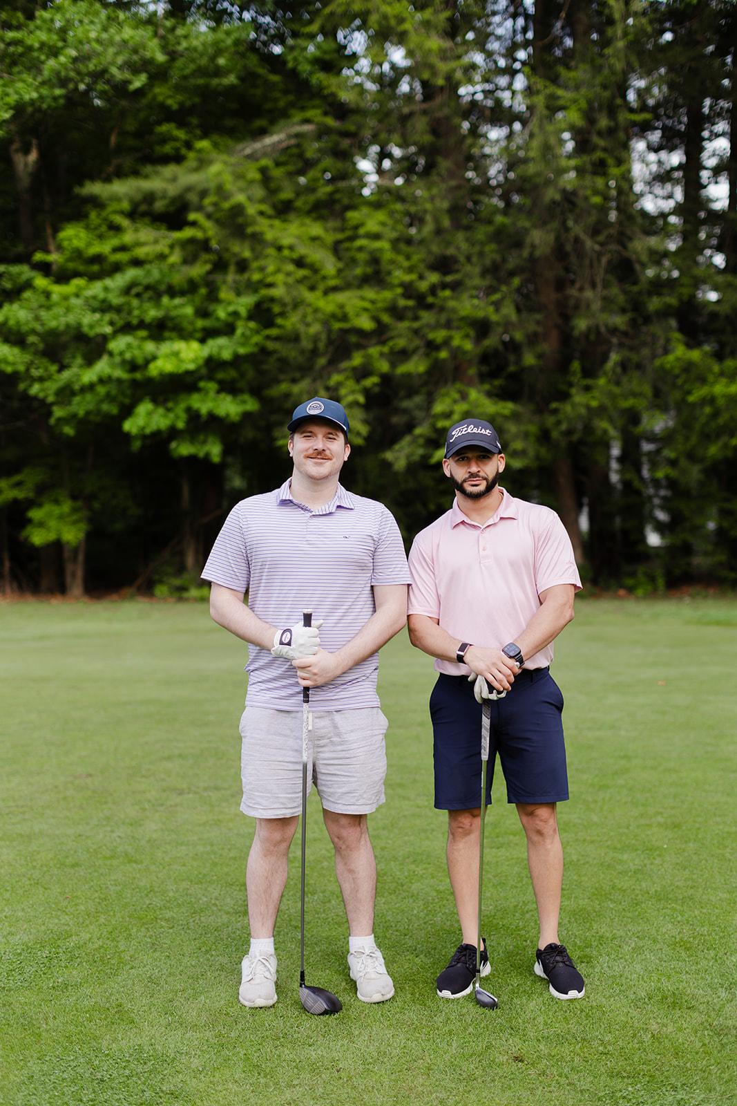 Two teammates standing at the tee box during the golf outing