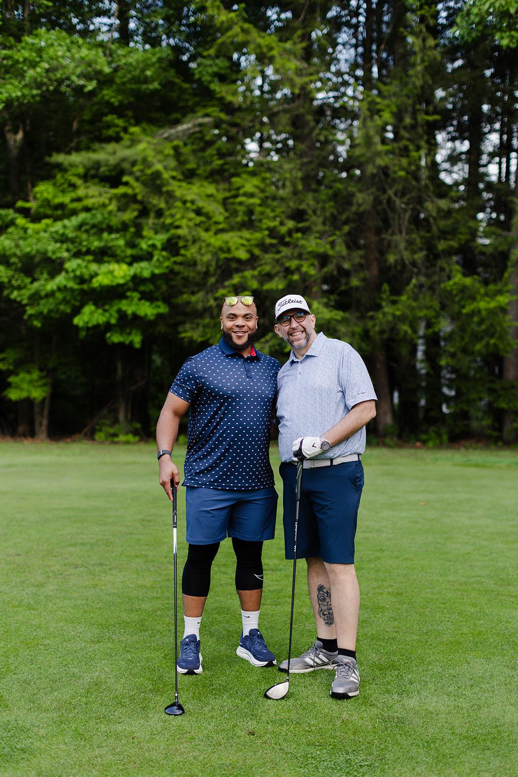 Two Patriot team members all smiles on the green at the golf outing